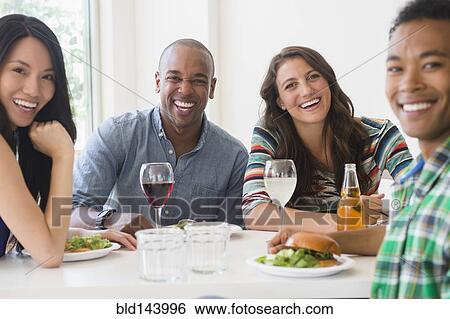 Friends eating together at restaurant View Large Photo Image Stock Photograph - Friends eating together at restaurant. Fotosearch