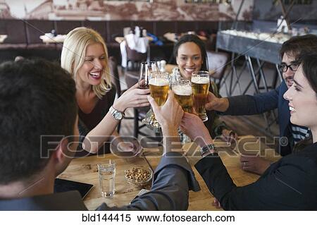 Friends toasting with beer in cafe View Large Photo Image Stock Photography - Friends toasting with beer in cafe. Fotosearch