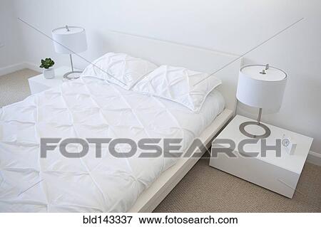 Stock Photo - High angle view of bed and night tables in modern bedroom. Fotosearch