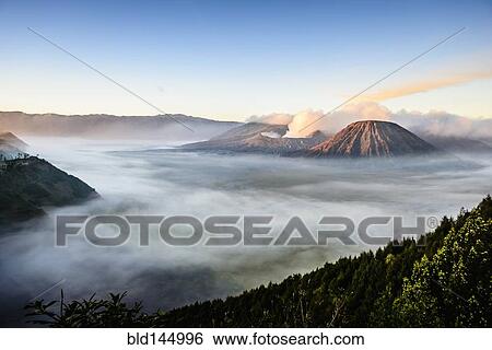 High angle view of clouds under smoking volcano View Large Photo Image Stock Photograph - High angle view of clouds under smoking volcano. Fotosearch
