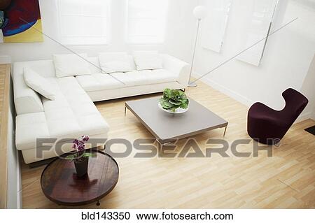 Stock Image - High angle view of coffee tables and sofas in modern living room. Fotosearch