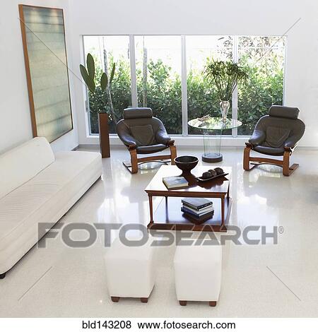 Stock Photo - High angle view of ottomans, sofa, armchairs and coffee table in living room. Fotosearch