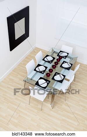 Stock Photo - High angle view of set table and chairs in modern dining room. Fotosearch