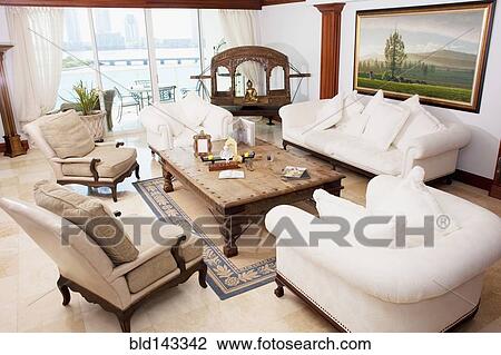 Stock Image - High angle view of sofas and armchairs in ornate living room. Fotosearch