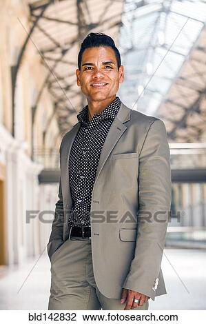 Stock Image - Hispanic businessman smiling indoors. Fotosearch