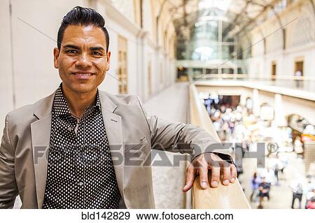 Stock Photo - Hispanic businessman standing on upper level. Fotosearch