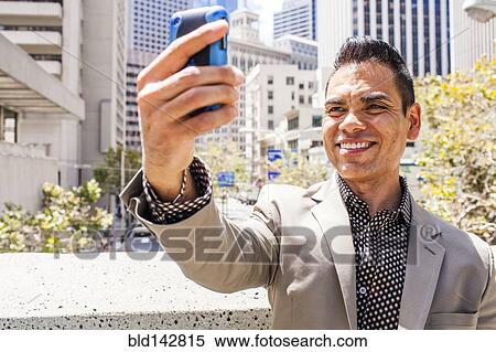 Hispanic businessman taking cell phone selfie View Large Photo Image Stock Photography - Hispanic businessman taking cell phone selfie. Fotosearch