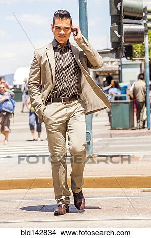Hispanic businessman talking on cell phone in urban crosswalk View Large Photo Image Picture - Hispanic businessman talking on cell phone in urban crosswalk. Fotosearch