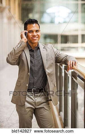 Stock Photo - Hispanic businessman talking on cell phone. Fotosearch