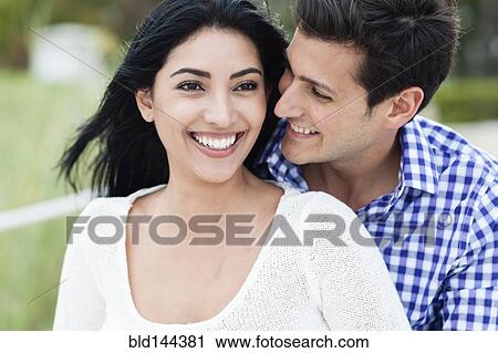 Stock Image - Hispanic couple smiling outdoors. Fotosearch
