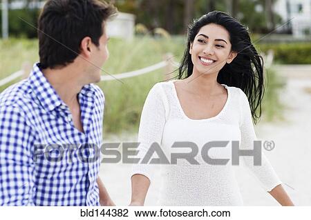 Stock Image - Hispanic couple walking outdoors. Fotosearch