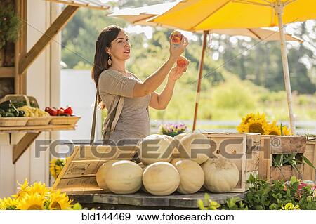 Hispanic woman browsing fruit at farmers market View Large Photo Image Stock Photo - Hispanic woman browsing fruit at farmers market. Fotosearch