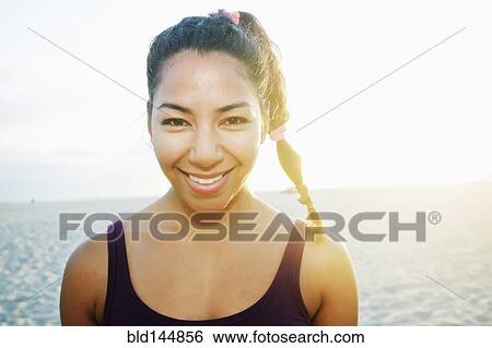Stock Photograph - Hispanic woman smiling at beach. Fotosearch