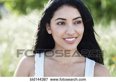 Stock Photo - Hispanic woman smiling outdoors. Fotosearch