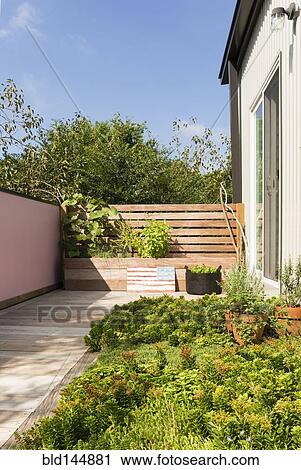 Stock Image - Landscaping and patio of modern condo building. Fotosearch