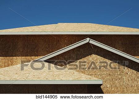 Stock Photography - Low angle view of chip board walls of house under construction. Fotosearch