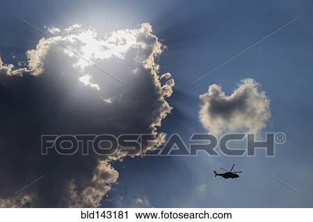 Low angle view of helicopter flying in cloudy sky View Large Photo Image Stock Image - Low angle view of helicopter flying in cloudy sky. Fotosearch