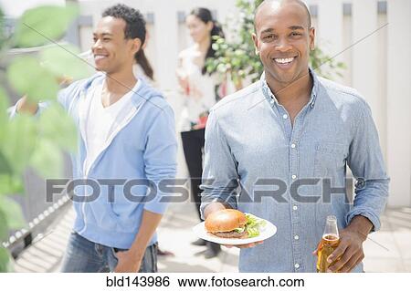 Man having beer and burger at backyard barbecue View Large Photo Image Stock Photograph - Man having beer and burger at backyard barbecue. Fotosearch