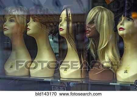 Stock Image - Mannequins and wigs in store window. Fotosearch