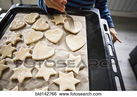 Stock Photograph - Mari boy baking cookies in kitchen. Fotosearch
