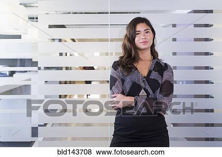 Stock Photo - Mixed race businesswoman standing in office. Fotosearch