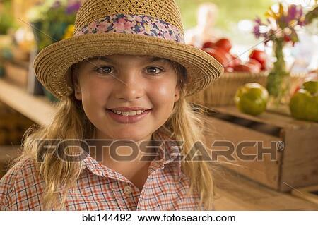 Stock Image - Mixed race girl smiling at farmers market. Fotosearch