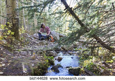 Mixed race hiker resting in forest View Large Photo Image Stock Photo - Mixed race hiker resting in forest. Fotosearch