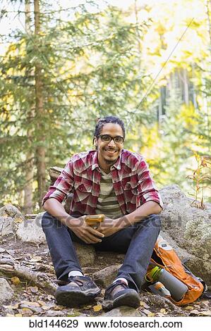 Stock Photo - Mixed race hiker smiling in forest. Fotosearch