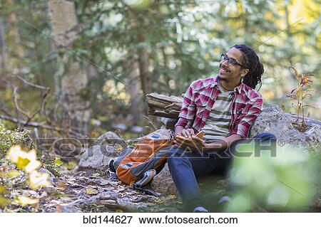 Mixed race hiker writing in forest View Large Photo Image Stock Photo - Mixed race hiker writing in forest. Fotosearch