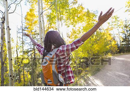 Picture - Mixed race man hiking in forest. Fotosearch