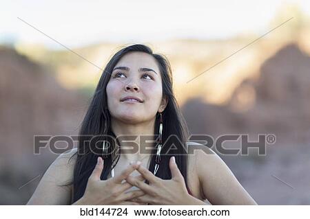 Picture - Mixed race woman meditating in desert. Fotosearch