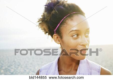 Stock Photography - Mixed race woman smiling at beach. Fotosearch