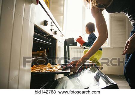 Stock Photo - Mother and son baking cookies in kitchen. Fotosearch