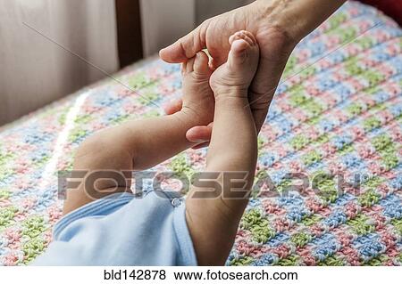 Mother holding feet of baby boy View Large Photo Image Stock Photo - Mother holding feet of baby boy. Fotosearch