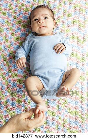 Stock Photo - Mother tickling foot of baby boy. Fotosearch