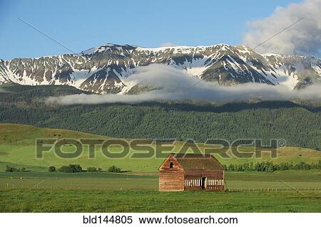 Stock Photography - Mountains over barn in rural landscape. Fotosearch