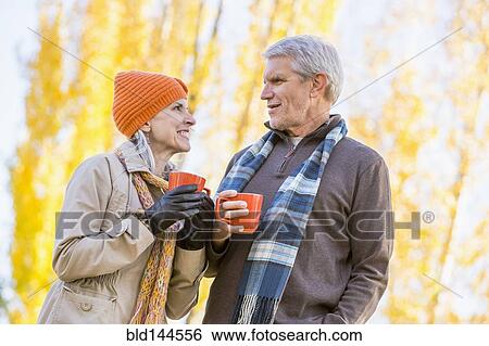 Older Caucasian couple drinking coffee near autumn trees View Large Photo Image Stock Photograph - Older Caucasian couple drinking coffee near autumn trees. Fotosearch