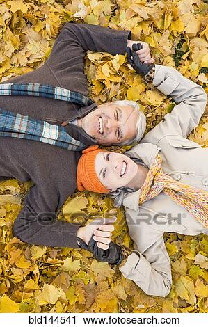 Older Caucasian couple smiling in autumn leaves View Large Photo Image Stock Image - Older Caucasian couple smiling in autumn leaves. Fotosearch