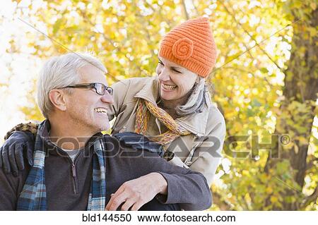 Older Caucasian couple smiling under autumn trees View Large Photo Image Stock Image - Older Caucasian couple smiling under autumn trees. Fotosearch
