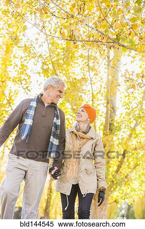 Older Caucasian couple walking under autumn trees View Large Photo Image Stock Photography - Older Caucasian couple walking under autumn trees. Fotosearch