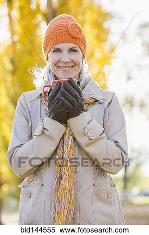 Older Caucasian woman drinking coffee near autumn trees View Large Photo Image Stock Photography - Older Caucasian woman drinking coffee near autumn trees. Fotosearch