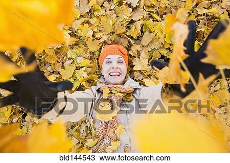 Older Caucasian woman playing in autumn leaves View Large Photo Image Stock Image - Older Caucasian woman playing in autumn leaves. Fotosearch