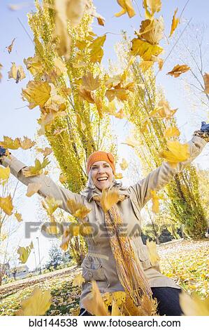 Older Caucasian woman playing in autumn leaves View Large Photo Image Stock Photo - Older Caucasian woman playing in autumn leaves. Fotosearch