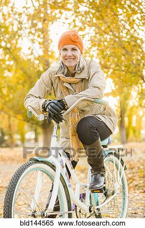 Older Caucasian woman riding bicycle on autumn leaves View Large Photo Image Stock Photography - Older Caucasian woman riding bicycle on autumn leaves. Fotosearch