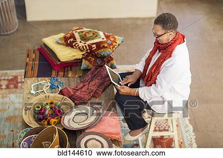 Older mixed race woman using digital tablet in home office View Large Photo Image Stock Image - Older mixed race woman using digital tablet in home office. Fotosearch
