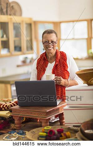 Older mixed race woman using laptop in home office View Large Photo Image Stock Photography - Older mixed race woman using laptop in home office. Fotosearch