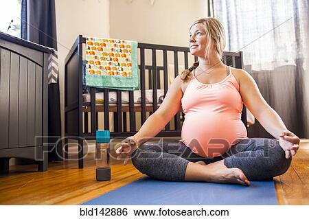 Pregnant Caucasian woman meditating in nursery View Large Photo Image Stock Photograph - Pregnant Caucasian woman meditating in nursery. Fotosearch