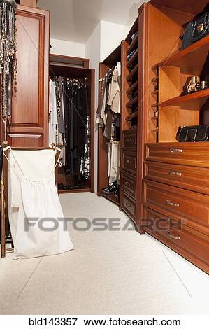 Shelves and hanging clothes in walk-in closet View Large Photo Image Stock Photo - Shelves and hanging clothes in walk-in closet. Fotosearch