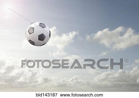 Soccer ball flying in cloudy sky View Large Photo Image Stock Photo - Soccer ball flying in cloudy sky. Fotosearch