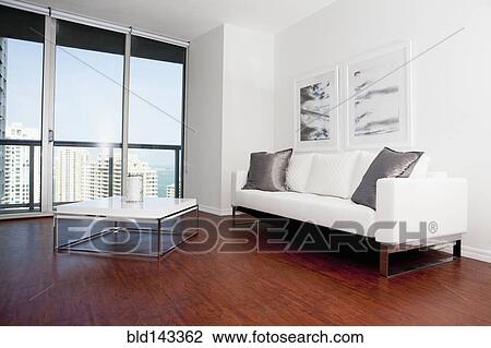 Stock Image - Sofa, coffee table and windows in modern living room. Fotosearch